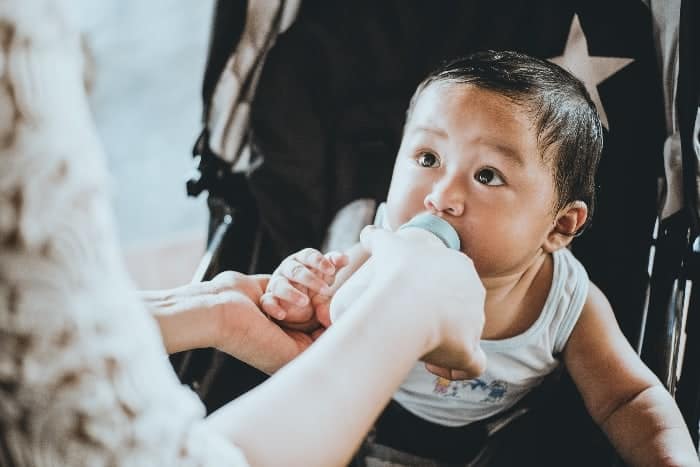 little boy eating bottle